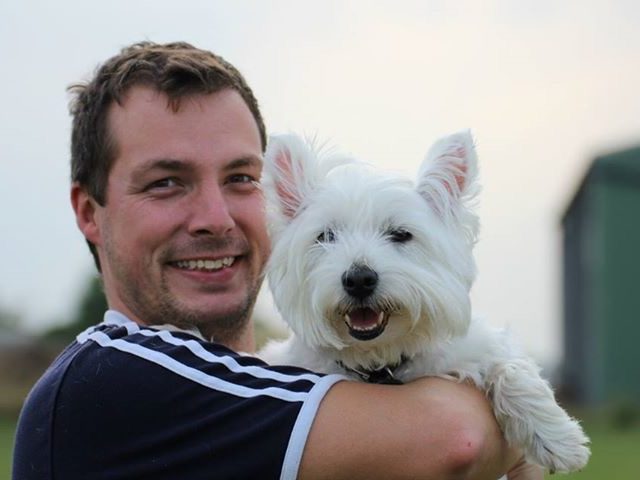 Happy dog owners A man smiles while playfully interacting with a dog.